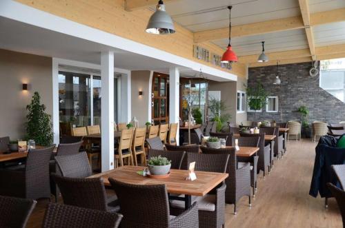 a restaurant with wooden tables and chairs at Hotel Rheinstein in Rüdesheim am Rhein