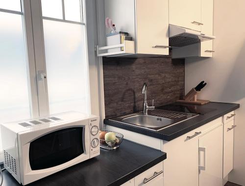 a kitchen with a microwave and a sink at Chalet Maria Interlaken in Interlaken