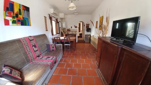 sala de estar con sofá y TV de pantalla plana en La Quinta Residencia en Salta