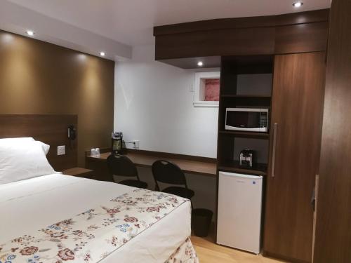 a hotel room with a bed and a microwave at Motel Chez Nous in Laval