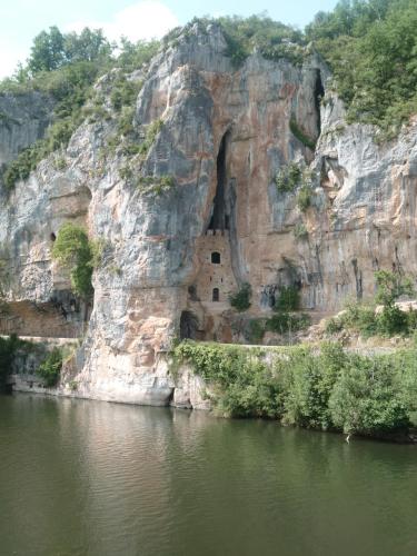 a rock cliff next to a body of water at Hôtel Restaurant Les Falaises in Bouziès