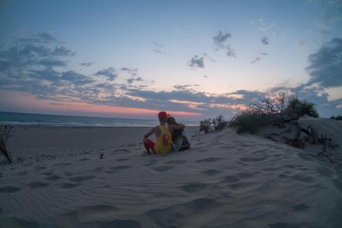 two people sitting in the sand on the beach at Hotel Sema in Patara