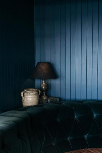 a lamp sitting on a couch with a blue wall at Anchorage Port Stephens in Nelson Bay