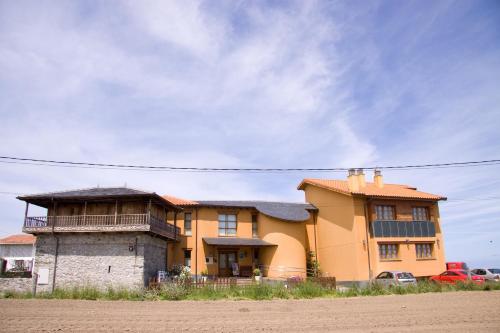 a large yellow house sitting on the side of a road at Astur Regal in Cadavedo