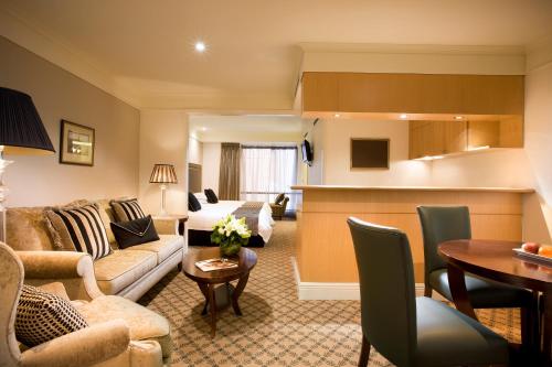 a living room with a couch and a table at Stamford Plaza Melbourne in Melbourne