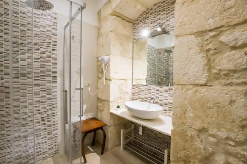 uma casa de banho com um lavatório e um chuveiro em La Sicilia in un sogno em Siracusa