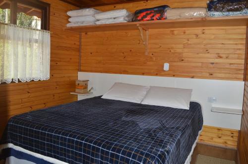 1 dormitorio con 1 cama en una cabaña de madera en Meu Cantinho, en Monte Verde