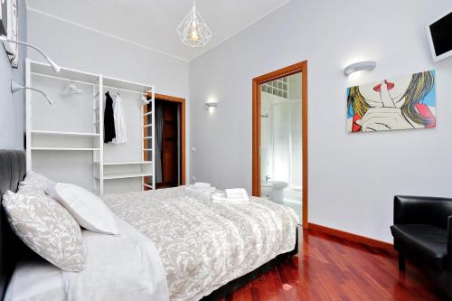 a white bedroom with a bed and a chair at Sapphire Apartment in Rome