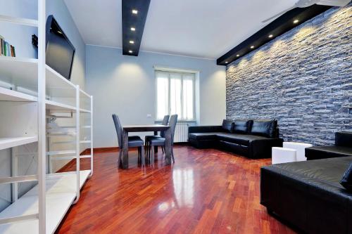 a living room with a table and a brick wall at Sapphire Apartment in Rome