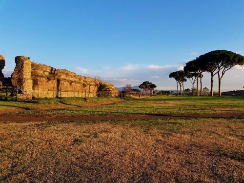 a field with trees and a rock wall at Sapphire Apartment in Rome