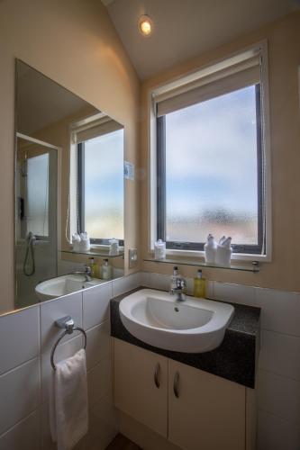 a bathroom with a sink and a large window at Abbella Lodge Motel in Christchurch