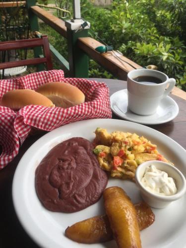 a plate of food on a table with a cup of coffee at Las Tilapias Hotel in San Ignacio