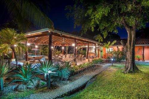 a restaurant with tables and chairs under a roof at night at Hotel Bahia Esmeralda in Potrero