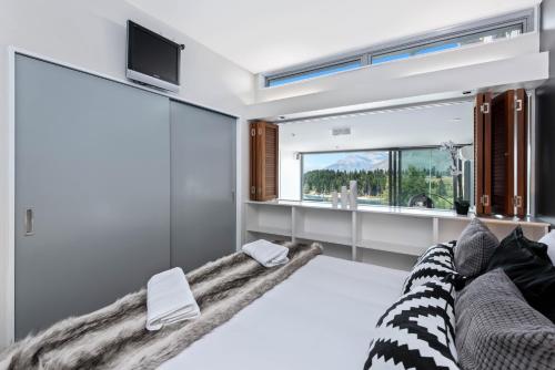a bedroom with a large bed with a large window at Hello QT Pounamu in Queenstown