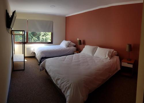 a hotel room with two beds and a window at Espacio VERT by Maigcalu in Padre Las Casas