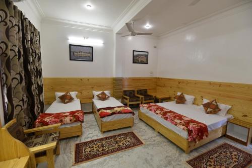 a hotel room with two beds and a couch at Balbir Niwas Guesthouse Homestay in Udaipur