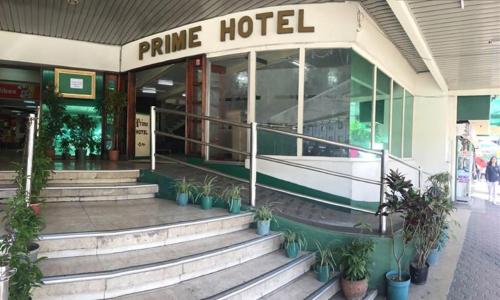 uma loja em frente a um hotel de pinho com escadas em frente em Benguet Prime Hotel em Baguio