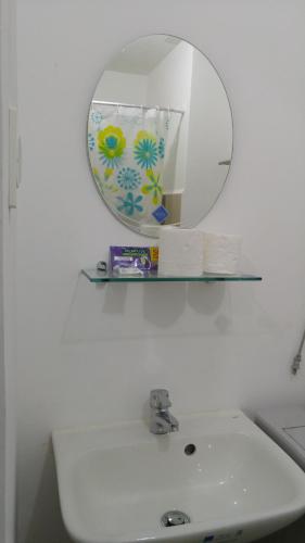 ein Badezimmer mit einem weißen Waschbecken und einem Spiegel in der Unterkunft 1BR Grace Residences w/ Internet- near BGC/McKinley in Manila
