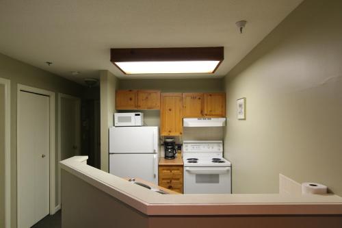 a kitchen with a white refrigerator and a stove at Marketplace Lodge by Whistler Retreats in Whistler