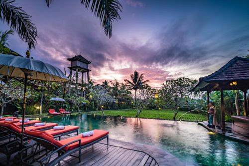 a swimming pool with lounge chairs and a resort at Bliss Ubud Spa Resort in Ubud