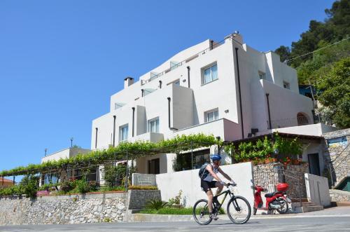 a man riding a bike in front of a building at Hotel La Gioiosa in Finale Ligure