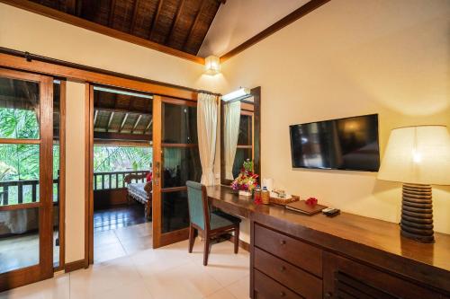 a home office with a desk and a television at Bliss Ubud Spa Resort in Ubud