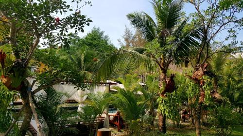 a group of palm trees in front of a building at Sahaa Beach Resort in Sihanoukville