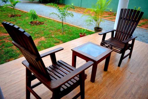 two chairs and a coffee table on a deck at Blue Sky Hotel Yala in Yala