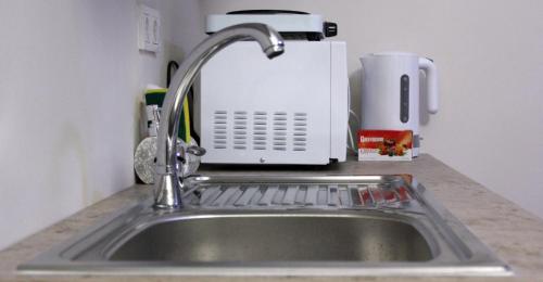 a kitchen sink with a faucet and a toaster at Nelly Guesthouse in Istanbul