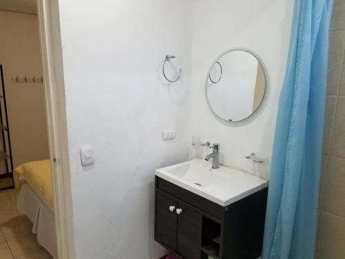 a bathroom with a sink and a mirror at Runway 108 in Managua