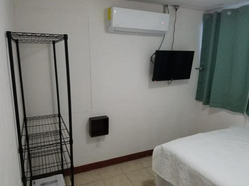 a room with a bed and a television in a room at Runway 108 in Managua