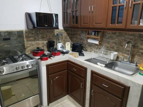 a kitchen with a stove and a sink at Runway 108 in Managua