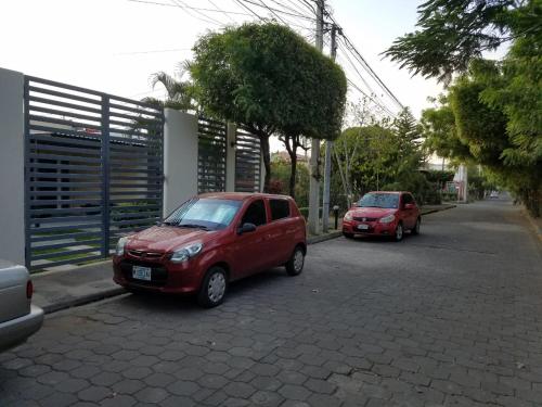 two red cars parked on the side of a street at Runway 108 in Managua