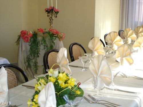 a table with white table cloths and flowers on it at Hotel Ristorante Borgo La Tana in Maratea