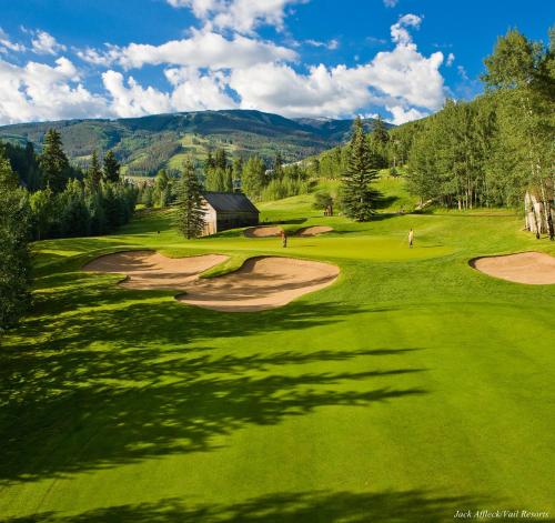 a view of a golf course with mountains in the background at Poste Montane Lodge by East West in Beaver Creek