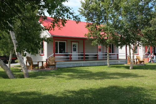 a red and white house with a red roof at Motel et Chalets Bo-Fleuve Evangeline in Saint-Siméon