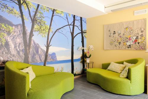 a living room with two green chairs and a large window at Eco Hotel Bonapace in Nago-Torbole