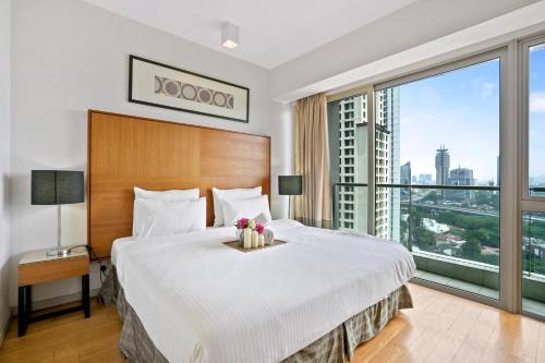 a bedroom with a large bed and a large window at MyHabitat by Plush in Kuala Lumpur