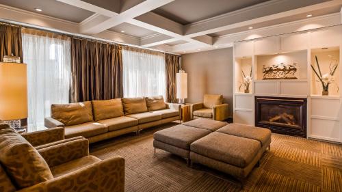 a living room with a couch and a fireplace at Best Western Premier Hotel Aristocrate in Quebec City