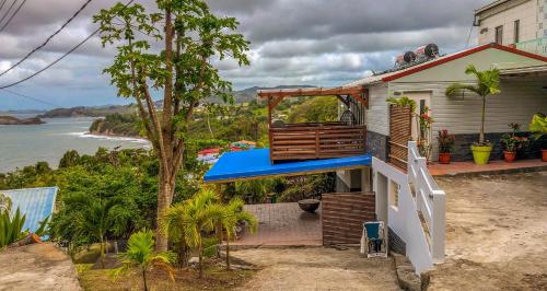 a house with a blue roof and a view of the ocean at Résidence Nakiya in Sainte-Marie