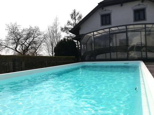a large swimming pool in front of a house at Ferienwohnung Wachmann in Rohrbach am Kulm