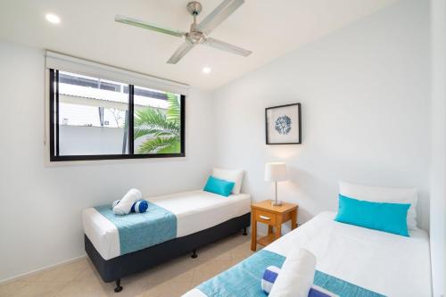a bedroom with two beds and a window at Saltwater Luxury Apartments in Port Douglas