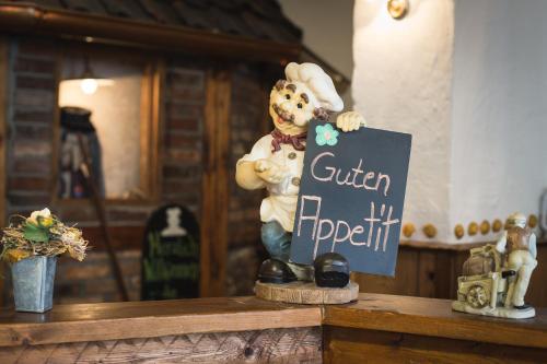 a statue of a bear holding a sign on a counter at Altwernigeröder Apparthotel in Wernigerode