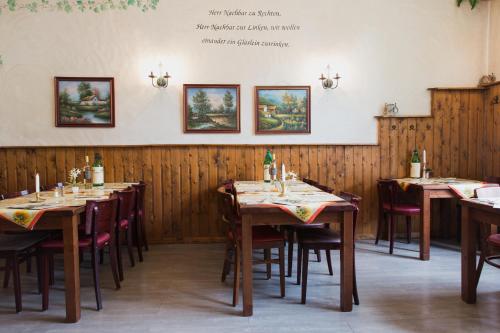 a row of tables in a restaurant with wooden walls at Altwernigeröder Apparthotel in Wernigerode