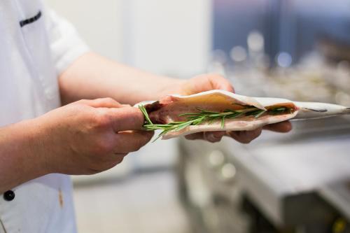 a person holding a fish on a plate at Altwernigeröder Apparthotel in Wernigerode