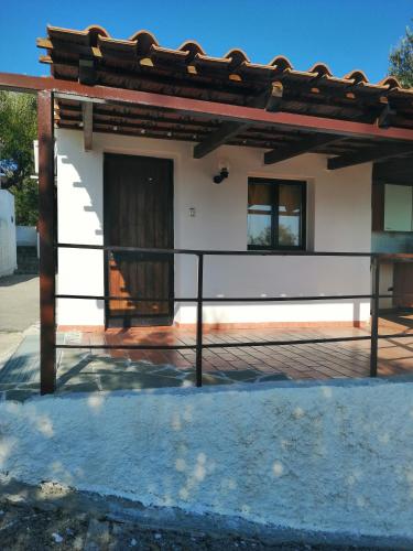 a house with a wooden door and a balcony at Residence Punta Cilento in Pisciotta