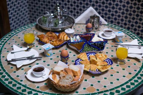 een tafel met een ontbijt van brood en jus d'orange bij Dar Meknes Tresor in Meknès