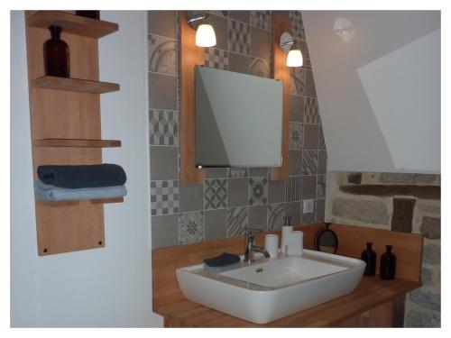 a bathroom with a white sink and a mirror at A L'Ombre du Tilleul in Comiac
