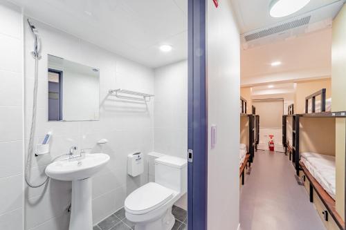 Łazienka z białą toaletą i umywalką w obiekcie Guesthouse Dear Moon w Pusanie