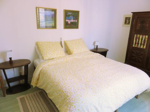 a bedroom with a bed and two night stands and two tables at Lemoniegites in Lemonie